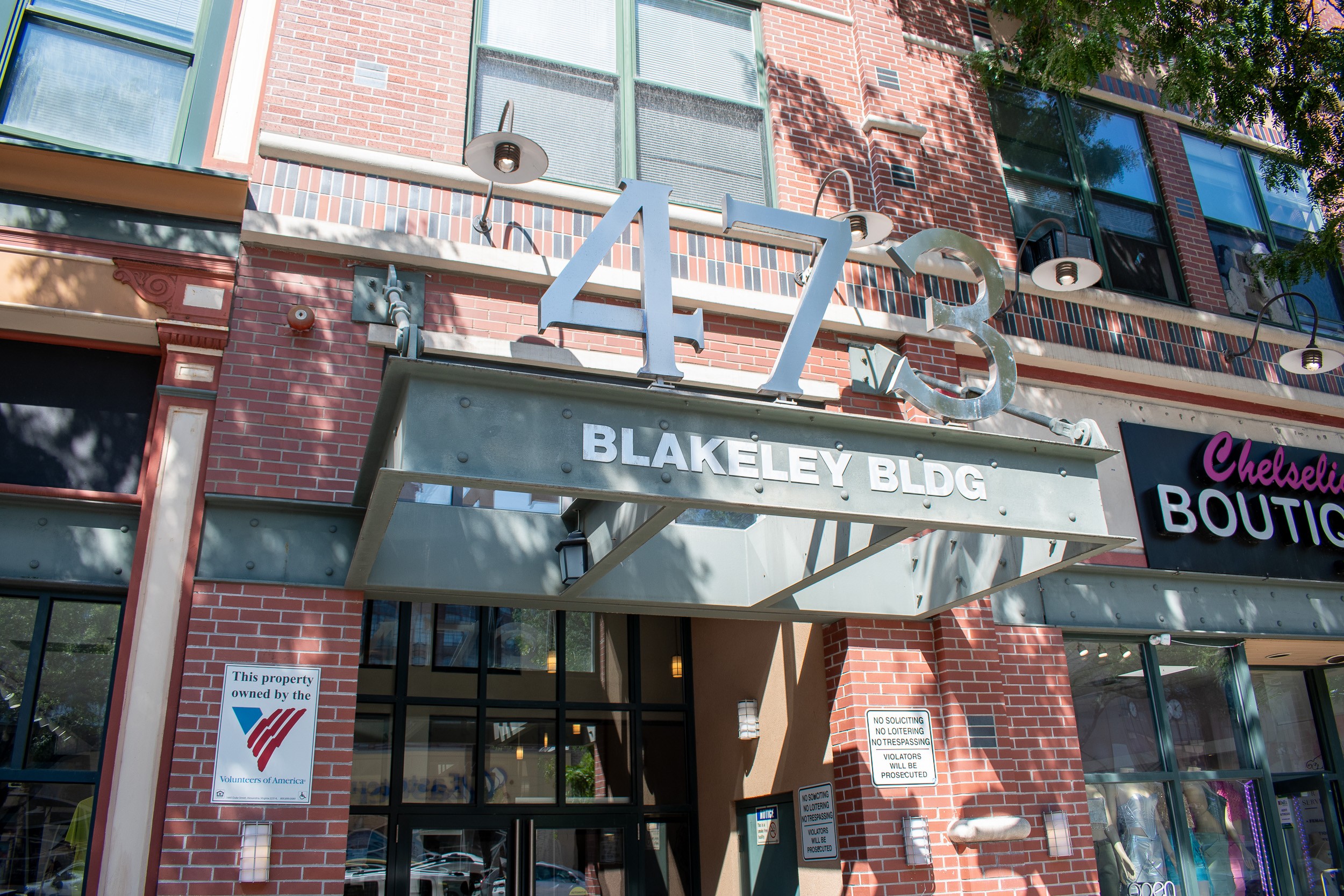 A sign for Blakeley Bldg is displayed above a Chelsleti Boutique.